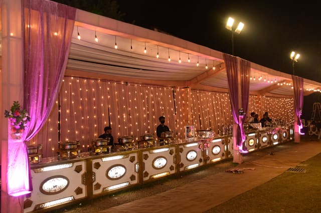 Live catering counter styled with drapes and string lights