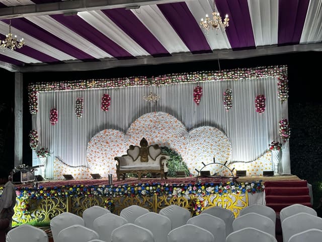 Decorated indoor banquet hall stage with floral backdrop